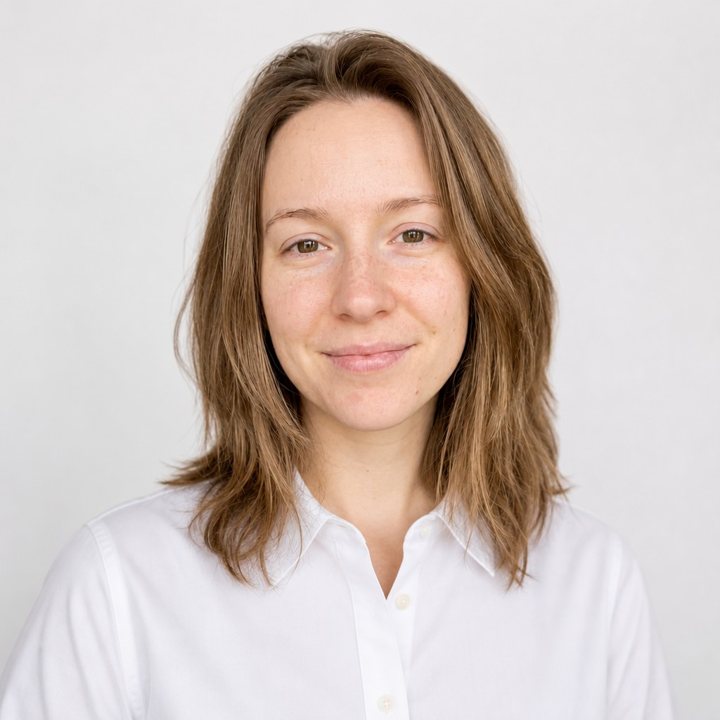 A professional headshot of a woman in a white shirt